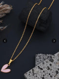 Pink love heart pendant necklace on gold chain against dark background