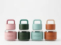 Four Apothecary glass bottles in pink, green, teal and terracotta colours